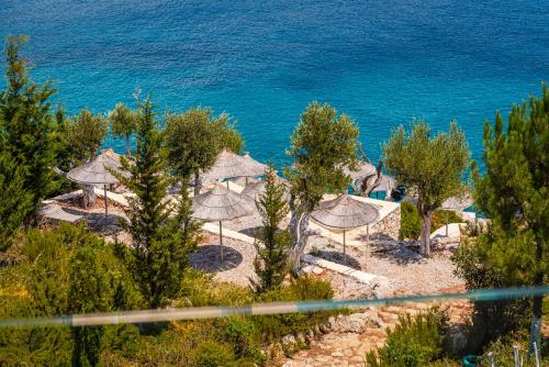 a view of a beach with umbrellas and the ocean at Stone Beach Residence - Adults Only Resort in Qeparo