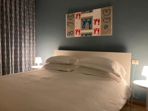 a bedroom with a bed with white sheets and pillows at Coloniola Lake House in Como