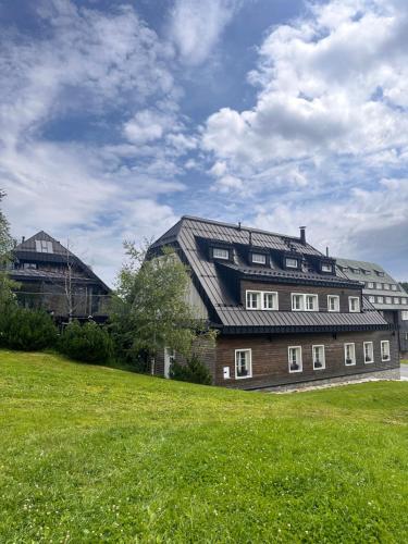 a large brick building with a roof on a field at Chata Hradečanka in Horní Malá Úpa