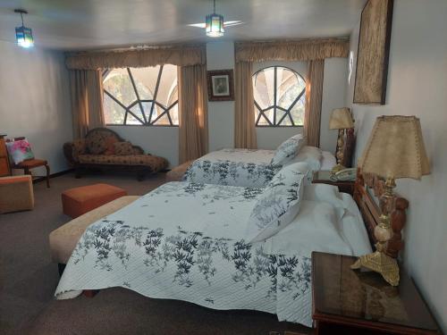 Un dormitorio con dos camas y una sala de estar. en Maison plaza Suit plaza de armas, en Arequipa