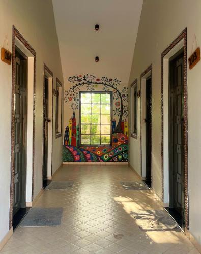 a hallway with a mural on the wall and a window at The Village Resort in Kodāe
