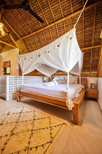 a bed with a mosquito net in a room at 360 Surf Camp in Kuta Lombok