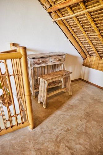a room with a wooden table and a staircase at 360 Surf Camp in Kuta Lombok