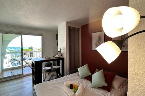Cet appartement comprend une chambre avec un lit et un salon avec un balcon. dans l'établissement 050 - Le Grand Mottois Studio, 2pers - 100m plage, à La Grande Motte