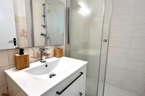 une salle de bain blanche avec un lavabo et une douche dans l'établissement 050 - Le Grand Mottois Studio, 2pers - 100m plage, à La Grande Motte