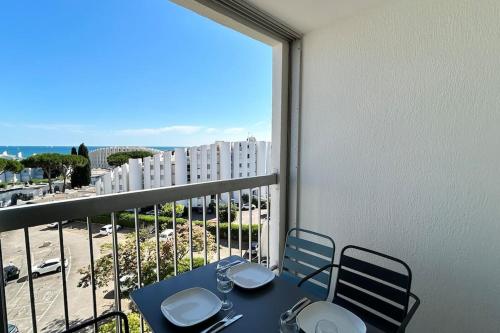 d'un balcon avec une table et des chaises et une vue sur un bâtiment. dans l'établissement 050 - Le Grand Mottois Studio, 2pers - 100m plage, à La Grande Motte