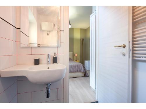 a bathroom with a white sink and a bedroom at Alex's Guest House in Rome