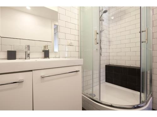 a white bathroom with a sink and a shower at Alex's Guest House in Rome