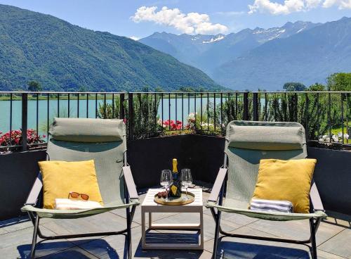 two chairs and a table on a balcony with mountains at Dascio Oasi Ferienwohnung Dachterrassen am See in Dascio