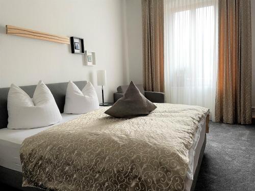 a bedroom with a large bed with pillows on it at Hotel & Restaurant Schloss Weißenburg in Uhlstädt