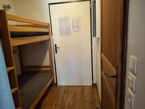 - une porte menant à une chambre avec des lits superposés dans l'établissement Charmant Studio à Brides-les-Bains avec Balcon, Parking et Wifi Inclus - FR-1-512-249, à Brides-les-Bains