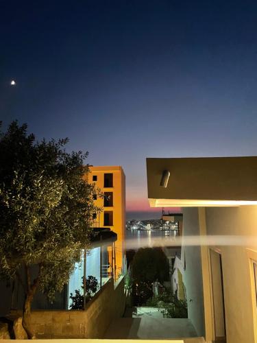 a building with a view of a river at night at Joal Rooms in Sarandë