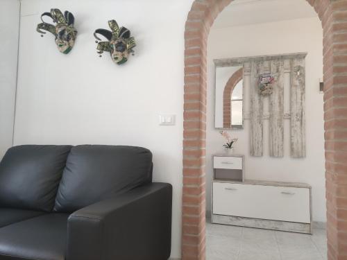 a living room with a black couch and a mirror at Al Capitello in Chioggia