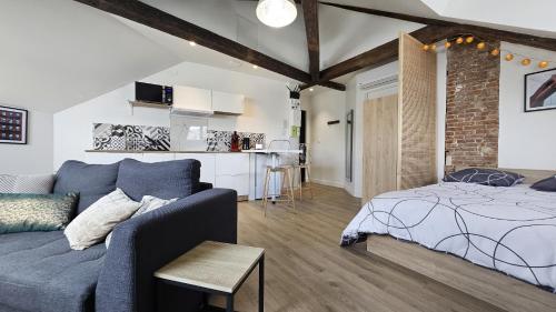 - un salon avec un canapé bleu et un lit dans l'établissement Maison Saint Surin, à Limoges