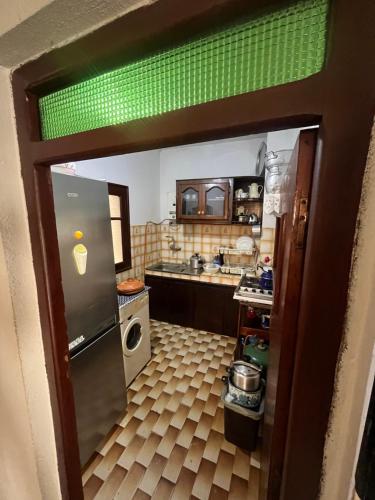 a small kitchen with a refrigerator and a stove at Lhaja house in Oued Laou