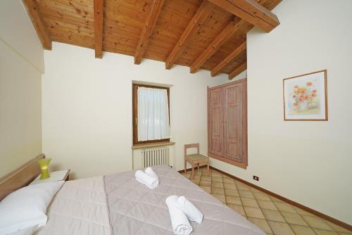 a bedroom with a bed with white towels on it at Residence La Filanda in Costermano sul Garda
