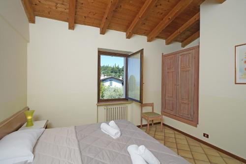 a bedroom with a large bed and a window at Residence La Filanda in Costermano sul Garda