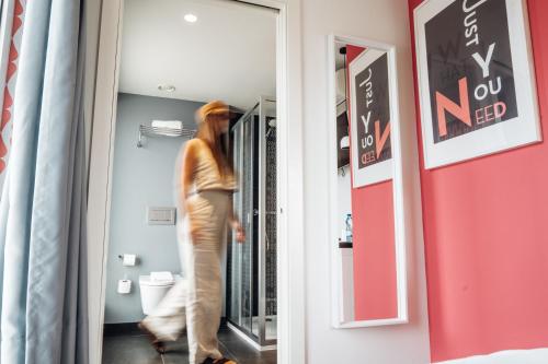 a woman walking a dog through a doorway at Stay Hotel Porto Centro Trindade in Porto