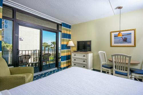 a hotel room with a bed and a table and chairs at Compass Cove in Myrtle Beach