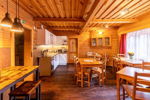 a kitchen and dining room with wooden tables and chairs at Apartmány Kubínska hoľa in Dolný Kubín