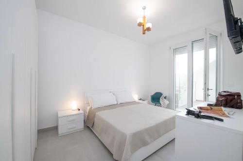 a white bedroom with a bed and a window at Casa Celeste con Piscina Privata a Otranto in Otranto
