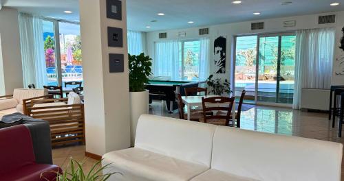 a living room with a white couch and a table at Hotel Apogeo - Breakfast Experience in Rimini