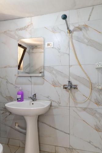 a bathroom with a sink and a shower at Disha Holiday Home in Ksamil