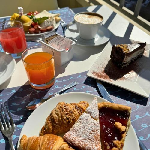a table with plates of pastries and coffee and drinks at Hotel Apogeo - Breakfast Experience in Rimini