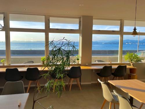 a room with tables and chairs and a large window at QUAYTH l キース in Shirahama