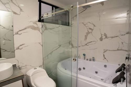 Un baño con ducha, inodoro y lavabo. en MV Departamento 2, en Baños