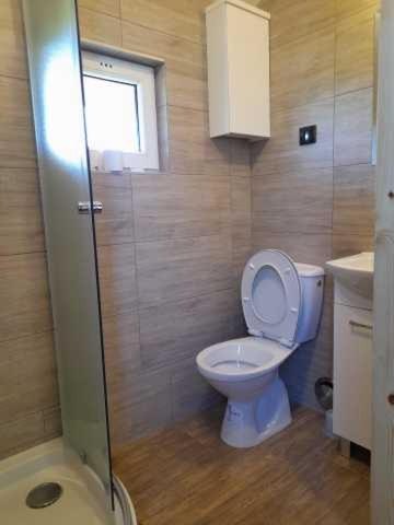 a bathroom with a toilet and a sink and a window at Domek nad stawem in Udryń