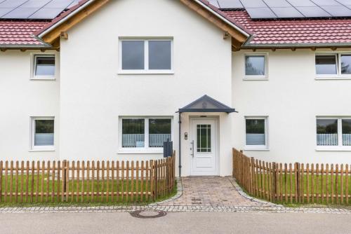a white house with a wooden fence at Haus Kellenburg in Albstadt