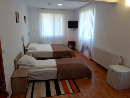 a hotel room with two beds and a television at CASA Dana in Praid