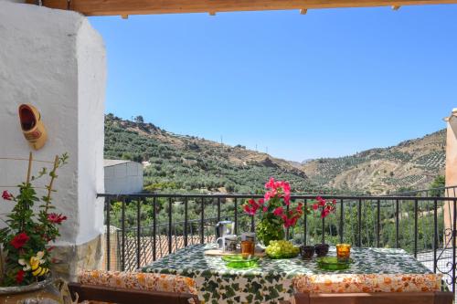 a table on a balcony with a view of a mountain at Casa Rural Pilón Azul in Belerdas