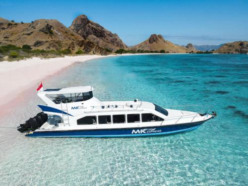 un barco en el agua junto a una playa en Oneday trip Labuanbajo, en Labuan Bajo