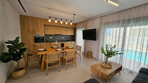 a kitchen and dining room with a table and chairs at Kooba Villas in Gázion