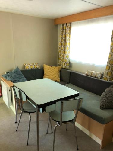 un salon avec un canapé, une table et des chaises dans l'établissement Camping La Châtaigneraie, à Gravières