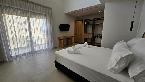 a bedroom with a large bed with white sheets and pillows at Kooba Villas in Gázion