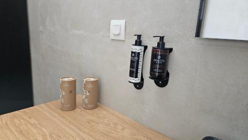 two bottles on a wall next to a wooden table at Kooba Villas in Gázion