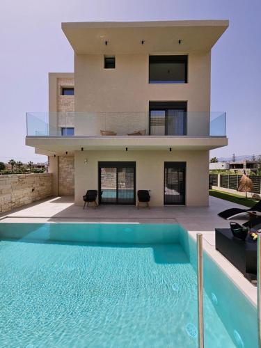 a house with a swimming pool in front of a house at Kooba Villas in Gázion