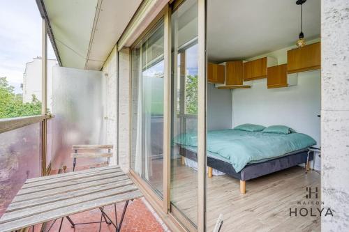 Cette chambre dispose d'un lit et d'un banc sur un balcon. dans l'établissement Le Fondamental - Proche Montparnasse - 252B, à Paris