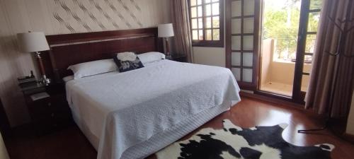 a bedroom with a bed with a teddy bear on it at Pousada da Paz in Curitiba
