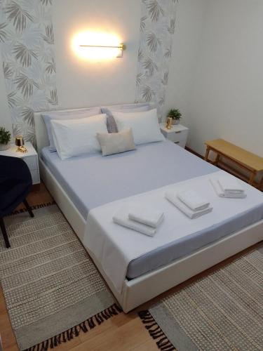 ein Schlafzimmer mit einem großen Bett mit weißen Laken und Kissen in der Unterkunft Nikolas House in Asprovalta