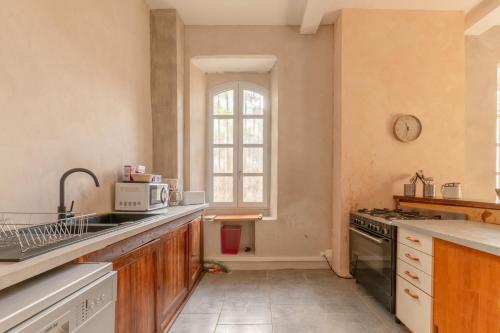 a kitchen with a sink and a stove at La Maison Tonio in Ossun