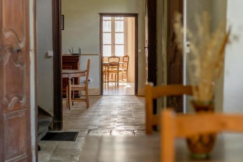 a hallway with a dining room and a table and chairs at La Maison Tonio in Ossun