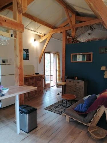 un salon avec une table et une salle à manger dans l'établissement le logis en bois, à Saint-Mathieu-de-Tréviers