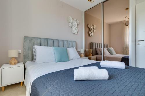 a bedroom with a large bed with two towels on it at Salt Bloom Apartments Nin in Nin
