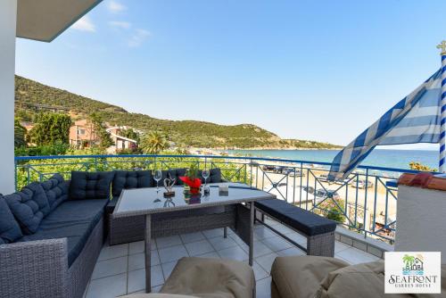 a balcony with a table and a view of the ocean at SeafrontGardenHouse Villa in Iraklitsa