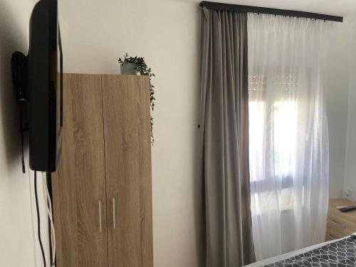 a television sitting on top of a cabinet next to a window at El apartamento Cristina in Gandía