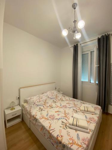 a bedroom with a bed and a chandelier at Oasis apartment in Zadar
